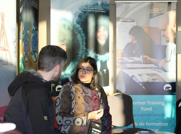 Industry, Tourism and Investment staff talking with tourism entrepreneur about GNWT tourism programming