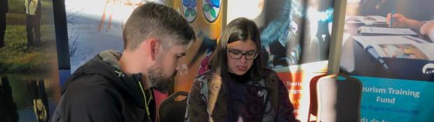 Industry, Tourism and Investment tourism employee sitting with entrepreneur providing information on GNWT programs and services